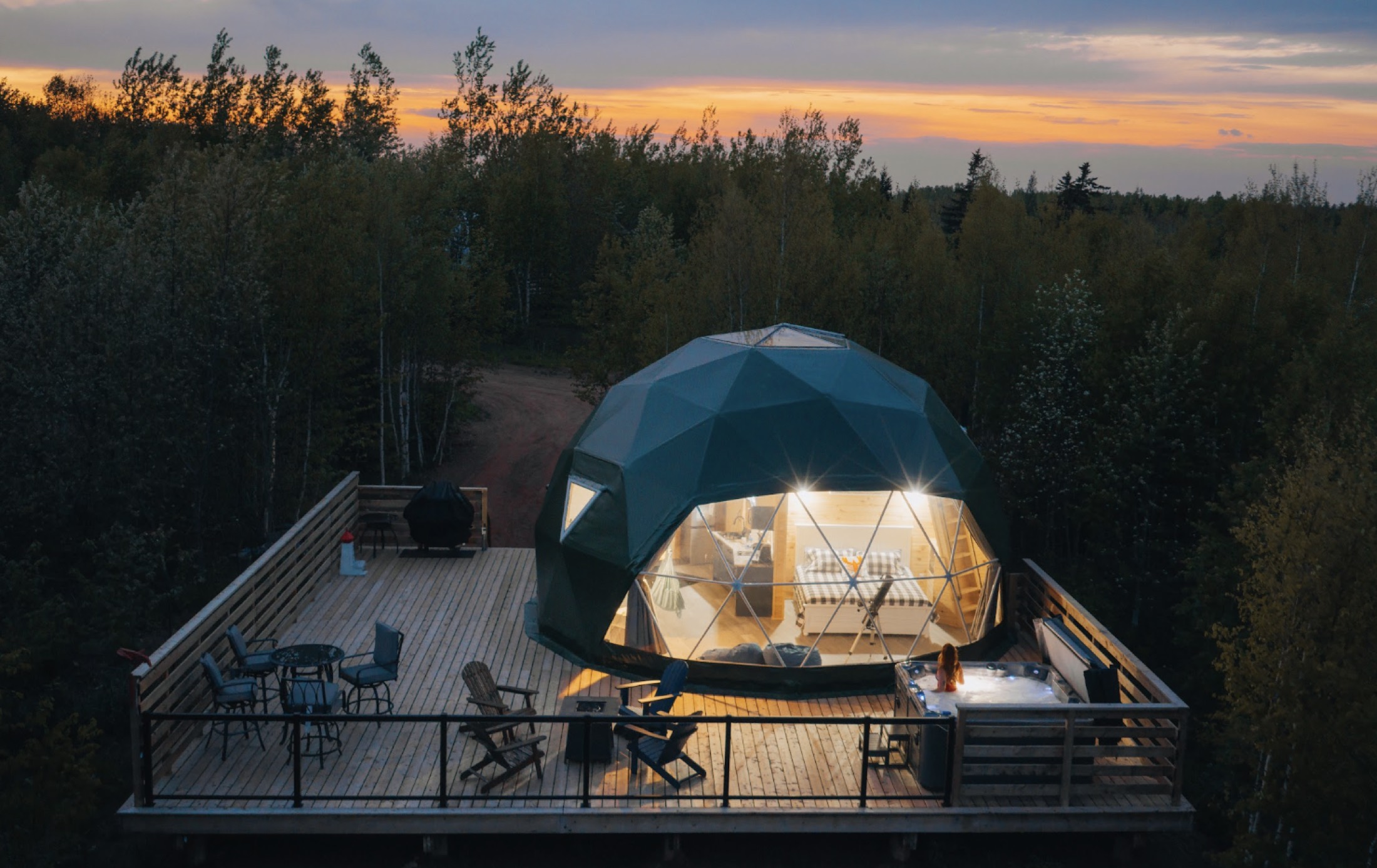 Aerial view of the glamping domes in the PEI forest at dusk